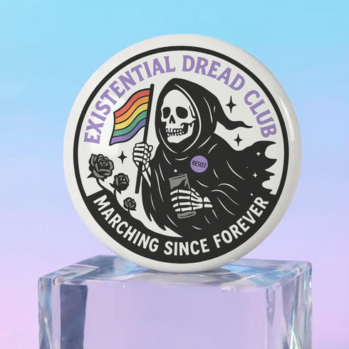 Round pinback button featuring a bold black and white design of a skeleton reaper holding a rainbow pride flag and a drink, wearing a "RESIST" badge, surrounded by black roses, with "Existential Dread Club" in purple letters and "Marching Since Forever" in white. Glossy, metal button in 2" or 3" size.