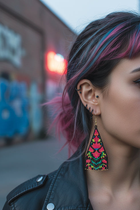 A close-up of a person's face wearing a black leather jacket and a large, colorful earring with a floral design.