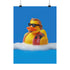 A quirky art print of a rubber duck styled after The Dude from The Big Lebowski, complete with a goatee, sunglasses, and plaid bathrobe. The duck lounges in bubbles, framed in a glossy red frame, with a manicured hand adjusting it against a monochromatic red backdrop.