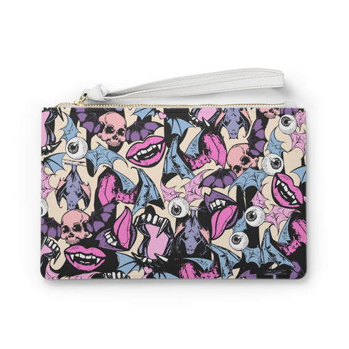 Rectangular wristlet clutch featuring a dark background with colorful bats, skulls, eyeballs, and vampire mouths. White strap and gold zipper visible.