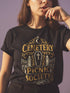A black unisex crewneck graphic t-shirt featuring an ornate Victorian-inspired emblem printed on the chest in vintage gold and off-white. The centralized, symmetrical design showcases a classic coffin with a cross on the lid, flanked by wrought-iron cemetery gates. Beautiful scrollwork and decorative filigree flourishes surround the bold, retro serif text reading CEMETERY PICNIC SOCIETY. A crescent moon and stars sit at the top, completing this gothic memento mori graphic shirt.