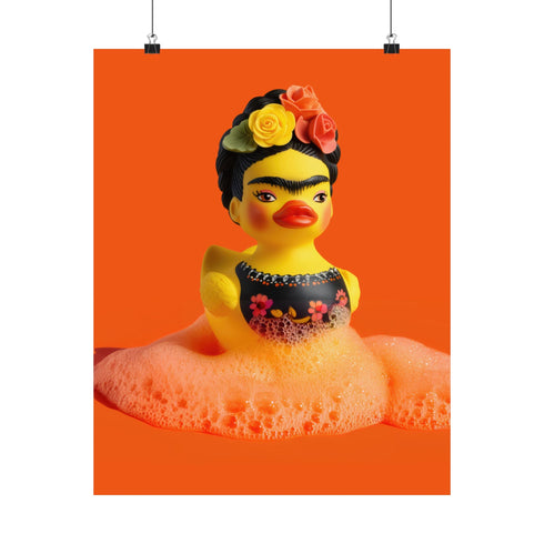 A vibrant fine art print of a rubber duck inspired by Frida Kahlo, complete with bold unibrow, floral crown, and traditional embroidered blouse. Framed in a red sculptural frame, the duck floats in orange-tinted bubbles against a deep orange backdrop and violet wall.