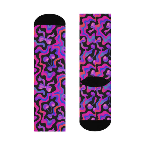Coquette-style crew socks featuring a bold black background with hot pink and purple psychedelic squiggles, cherries, and shiny pink bows. Made of a soft polyester-spandex blend with reinforced black toe and heel. Fits US women's sizes 5–12 and men's up to 12. Stretchy, colorful, and cute for dopamine dressing.