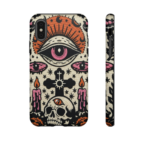 A vertical phone case design featuring a faux crochet texture illusion printed on a cream background. The symmetrical pattern centers on a large black eye with a pink iris and rust-orange sunburst lashes at the top. Below the eye is a black cross surrounded by small black stars. The bottom features a skull with a third rust-orange eye on its forehead. Flanking the skull are two candles with orange flames and rust-colored leaves. The design mimics the look of stitched yarn but is a 2d print.