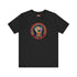Black short-sleeve t-shirt featuring a bold embroidered design centered on the chest. The design showcases a raised fist wrapped in multicolored thread, symbolizing strength and resistance. Surrounding the fist is a circular embroidered border with intricate, colorful stitching in shades of red, orange, blue, and yellow, creating a striking contrast against the black fabric. Below the fist, the word "RESIST" is embroidered in capital letters using a gradient of warm-toned thread. The t-shirt has a classic c