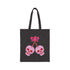 Canvas tote bag featuring pink skull cherries design. Two pink skulls connected by red stem and bow. Quirky gothic-inspired graphic on cream background. Stylish, edgy accessory for everyday use. Perfect for alternative fashion lovers.