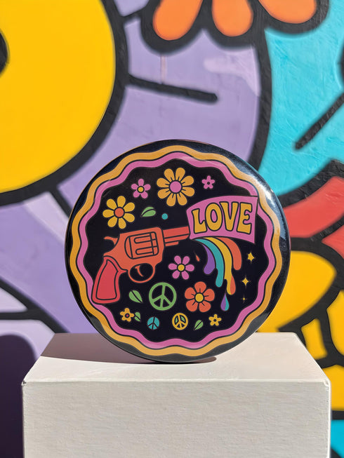 a button with a peace sign and a gun on it
