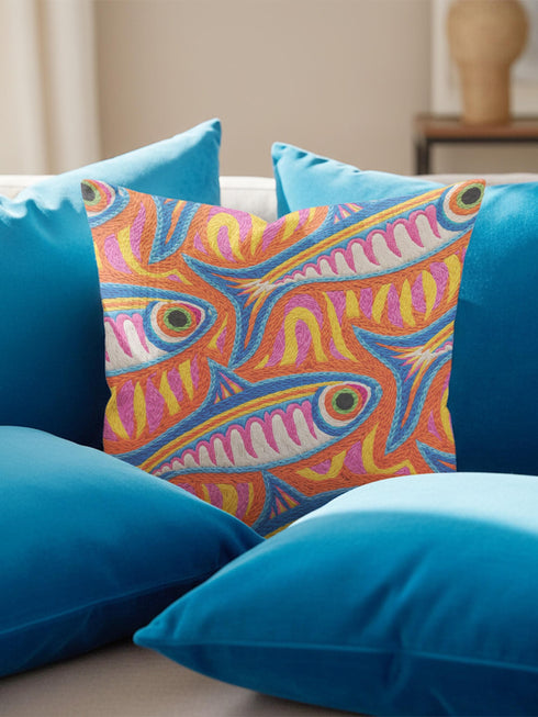 Flat printed square throw pillow cover featuring a faux embroidery texture. The vibrant maximalist design showcases stylized blue, pink, yellow, and white fish swimming in a dynamic, swirling pattern across a bright orange background. The artwork mimics heavy crewelwork yarn and stitching, but the material is a smooth 2D flat print. The pillow is shown as a finished square cover, designed to add bright, colorful eclectic fisherman aesthetic decor to any sofa or seating area.