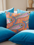 Flat printed square throw pillow cover featuring a faux embroidery texture. The vibrant maximalist design showcases stylized blue, pink, yellow, and white fish swimming in a dynamic, swirling pattern across a bright orange background. The artwork mimics heavy crewelwork yarn and stitching, but the material is a smooth 2D flat print. The pillow is shown as a finished square cover, designed to add bright, colorful eclectic fisherman aesthetic decor to any sofa or seating area.