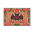 A rectangular beige doormat featuring a large, symmetrical folk art bat illustration in the center. The bat is black with coral red and mustard gold details that mimic the look of satin stitch embroidery. Surrounding the bat are stylized floral motifs in deep pink, coral, and olive green, arranged in a dense, decorative pattern. The texture visually resembles woven linen but is a smooth, flat print. The mat has a solid black trim border and is shown on a flat surface.