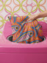 Flat printed square throw pillow cover featuring a faux embroidery texture. The vibrant maximalist design showcases stylized blue, pink, yellow, and white fish swimming in a dynamic, swirling pattern across a bright orange background. The artwork mimics heavy crewelwork yarn and stitching, but the material is a smooth 2D flat print. The pillow is shown as a finished square cover, designed to add bright, colorful eclectic fisherman aesthetic decor to any sofa or seating area.