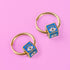 a pair of gold hoop earrings with evil eye on them