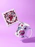 White porcelain 11oz mug and matching 4x4 inch square ceramic coaster set featuring a vibrant, maximalist full-wrap pattern. The design illustrates glossy pink vampire lips with white fangs and red tongues, interspersed with floating eyeballs, purple bats, and small pink skulls against a white background. The mug features a glossy finish and C-handle. The coaster has a matching glazed ceramic top and a brown cork backing. High-contrast pop-art style with pink, purple, and black details.