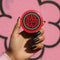 A round red pinback button with a glossy, scratch-resistant mylar face. The design features the phrase "HAIL SKATIN'" in a wavy, 70s psychedelic font in the center. This text is surrounded by a bold, black and white checkerboard pattern border, giving it a punk rock aesthetic. This piece of vintage-inspired flair is made of lightweight metal with a durable safety pin backing on the reverse. The button is a perfect for a denim jacket, backpack, or bag for fans of roller derby and skateboarding.