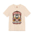 A short sleeve unisex crewneck t-shirt featuring a vintage style emblem graphic centered on the chest. The design features a red banner reading BAKE SALE above a black guillotine. Two crossed wooden rolling pins sit below the guillotine, above a layered pink and white cake with a cherry. The graphic is flanked by pink flowers, cherries, and stacks of gold coins. A bottom banner reads FOR THE GUILLOTINE FUND EST. WHENEVER THEY GOT TOO GREEDY. The shirt comes in light pink, cream, and blue.
