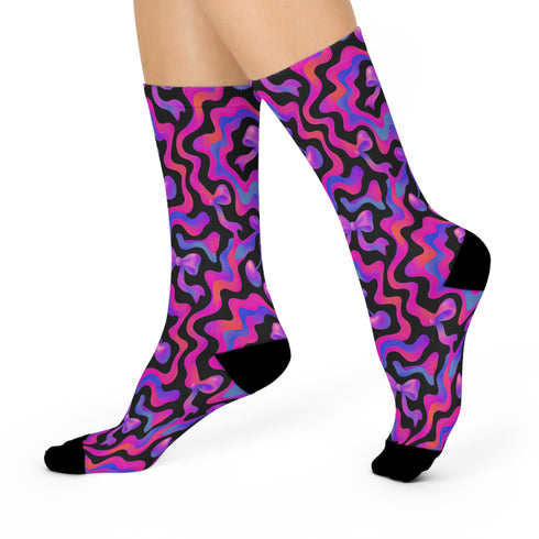 Coquette-style crew socks featuring a bold black background with hot pink and purple psychedelic squiggles, cherries, and shiny pink bows. Made of a soft polyester-spandex blend with reinforced black toe and heel. Fits US women's sizes 5–12 and men's up to 12. Stretchy, colorful, and cute for dopamine dressing.