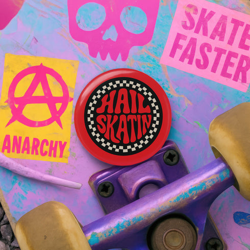 A round red pinback button with a glossy, scratch-resistant mylar face. The design features the phrase "HAIL SKATIN'" in a wavy, 70s psychedelic font in the center. This text is surrounded by a bold, black and white checkerboard pattern border, giving it a punk rock aesthetic. This piece of vintage-inspired flair is made of lightweight metal with a durable safety pin backing on the reverse. The button is a perfect for a denim jacket, backpack, or bag for fans of roller derby and skateboarding.