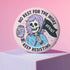 Honey Dazed Glossy round pink pinback button featuring a skeleton girl with purple hair holding a black flag that says “RESIST” and an energy drink can, with the phrases “No Rest for the Woke” and “Keep Resisting” in bold black letters.