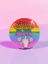 Round glossy pinback button measuring 2.25 inches with a bold rainbow pride flag background. Centered text reads “Still Not Asking For Your Opinion” in black, yellow, blue, and purple letters. Below the text is an illustrated hand with painted red nails giving the middle finger, surrounded by white daisies. The design is printed on tinplate with a scratch- and UV-resistant mylar coating. Button features a strong safety pin backing, perfect for bags, jackets, or pride outfits.