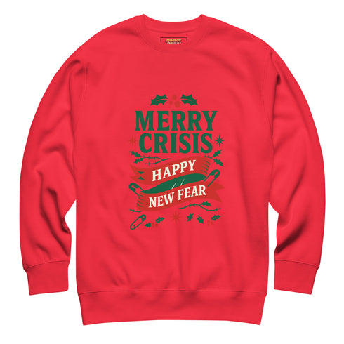 A holiday sweatshirt in pink or red with a punk and goth aesthetic. The text reads "MERRY CRISIS" and "HAPPY NEW FEAR" in a bold, gothic-style font. The design is decorated with holly leaves, berries, thorny vines, and safety pins, all arranged in a festive but alternative holiday style. This funny goth Christmas pullover is a sarcastic statement piece, perfect as dark humor apparel for the winter season.