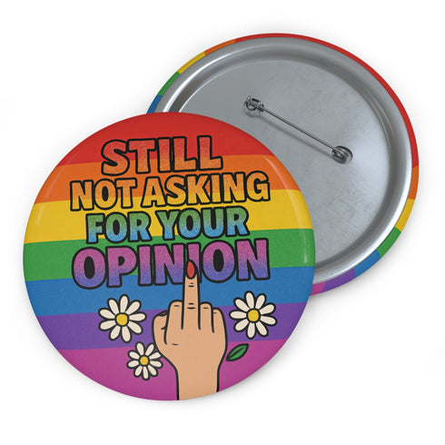 Round glossy pinback button measuring 2.25 inches with a bold rainbow pride flag background. Centered text reads “Still Not Asking For Your Opinion” in black, yellow, blue, and purple letters. Below the text is an illustrated hand with painted red nails giving the middle finger, surrounded by white daisies. The design is printed on tinplate with a scratch- and UV-resistant mylar coating. Button features a strong safety pin backing, perfect for bags, jackets, or pride outfits.