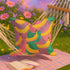 Colorful square pillow cover featuring a bold banana print in yellow, pink, green, purple, and black. The print appears on both sides and is made of luxe polyester with a linen-like texture. Hidden zipper closure. Available in two sizes: 22x22 inches and 18x18 inches. Designed for bright, dopamine-style, maximalist home decor.