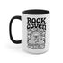 A two-tone ceramic mug with a glossy white exterior and a contrasting black interior, handle, and rim. The front of the mug features a black, rectangular graphic with the words "BOOK COVEN" in a bold, wavy, 70s-inspired retro font. Below the text is an occult-style illustration of an open book on a stand. An all-seeing eye with a snake coiled around it emerges from the book's pages, radiating lines of light. Smaller books float around the central image, completing the witchy, bookish design