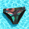 High-waisted bikini bottom with a gothic butterfly print in rich teal, plum, and midnight tones on a black background. Features kaleidoscopic wings forming a central butterfly motif across the front, with a flattering cheeky cut and double-layered fabric. Styled on a turquoise pool backdrop, this moody festival swimwear is perfect for soft goths, rave queens, and dark summer rebels.