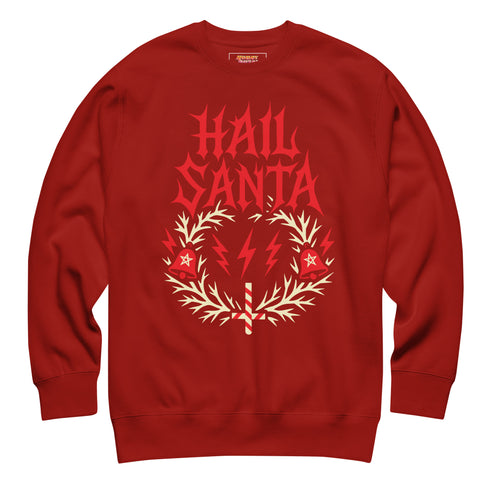 A unisex crewneck sweatshirt shown in red, green, and blue color options. The graphic features "HAIL SANTA" in a red, jagged, heavy metal-style font. The text is framed by a cream-colored wreath made of thorny branches. Inside the wreath are two red lightning bolts and two red bells with cream-colored pentagrams. An inverted candy cane cross sits at the bottom. This alternative holiday sweater has fleece texture, ribbed cuffs, and a classic fit, designed for goth, punk, and metalhead aesthetics.