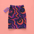 A colorful, abstract skirt with a pattern of swirling lines and shapes in shades of purple, orange, and pink.
