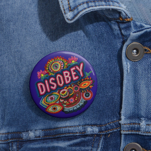 Stay Weird" black pinback button with pearl-effect lettering surrounded by folk art flowers in red and turquoise on a dark background.