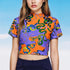 A vibrant see-through mesh crop top with a high mock neck and short sleeves. The shirt features a bold, all-over snake print pattern with colorful green, blue, yellow, and black serpents on a striking orange and purple color-block background. This Y2K-style top is a statement piece of witchy, goth, and alternative clothing, perfect for a maximalist rave outfit or edgy festival fashion from a black owned shop.