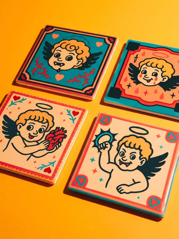 Set of four square ceramic coasters featuring a vampire cupid design in a pastel goth and traditional tattoo art style. The first coaster shows a fanged cherub on a teal background with red vines. The second features a cherub crying blood tears on a red background with daggers. The third depicts a cherub holding an anatomical heart on a peach background. The fourth shows a cherub with a spiked ring. Glossy glazed finish with cork backing. Ideal for spooky home decor and anti-valentine gifts.