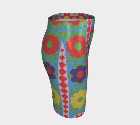 Form-fitting bodycon mini skirt with a mid-rise elastic waistband, falling to mid-thigh in smooth stretch fabric. It features a bold retro patchwork floral print: large mod daisies in red, purple, yellow, and green, set on a sky blue background with scattered green leaves. A central column frames single flowers on purple and pink tiles, edged by red and pink beaded borders. The all-over design is a flat dye-sublimated print, available in a smooth knit or glitter knit finish.