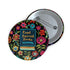 Round pinback button featuring a teal book with "Read Banned Books" in gold lettering on black background, surrounded by vibrant embroidery-style flowers in pink, orange, and blue. Literary protest pin with glossy finish and safety pin backing, available in 2" and 3" sizes for bookish fashion statements.