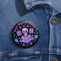 Literary rebel's badge of honor. Black circular button featuring a neon purple skeleton surrounded by floating books and stars. The text 'READ BANNED BOOKS' arcs across the top in bold purple lettering. Perfect for book-loving misfits who devour forbidden knowledge.