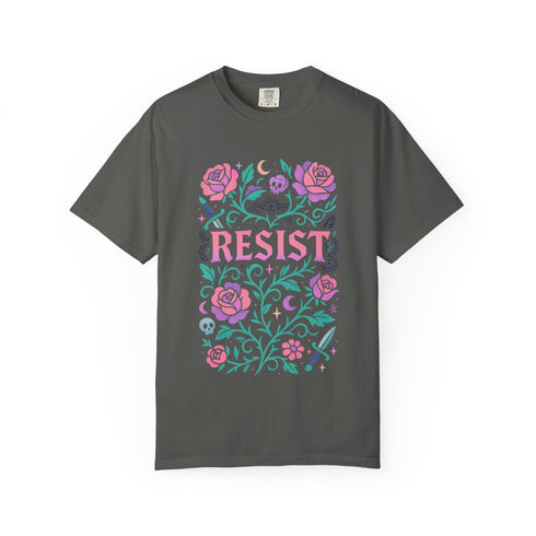 Comfort Colors 1717 unisex garment-dyed t-shirt featuring a front floral graphic with the word RESIST in pink block letters surrounded by green vines, purple roses, skulls, moons, and daggers. Made of soft-washed 100% ring-spun cotton with tubular knit construction, available in sizes S to 4XL.