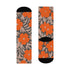Colorful mid-calf crew socks featuring a bold orange hibiscus floral pattern layered over wavy zebra stripes in taupe and gray, with black heels and toes.