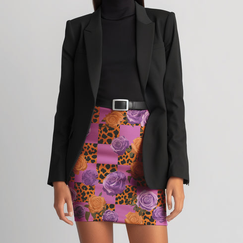 A woman wearing a black blazer, a short skirt with a floral print, and a belt.