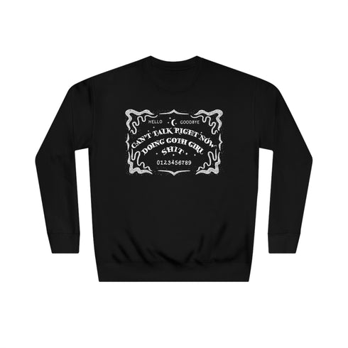 Black sweatshirt featuring white ouija board design with text "CAN'T TALK RIGHT NOW DOING GOTH GIRL SHIT". Ornate border surrounds the design, giving a mystical, witchy vibe.