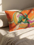 Rectangular 20x12 inch lumbar pillow cover in bright orange featuring printed faux embroidery of a green frog wearing a pink cowgirl hat and pink cowboy boots, lounging on a golden yellow crescent moon shaped like a peeled banana, surrounded by cream and gold sparkle stars and retro wavy stripes. Whimsical cowboy frog design printed on both sides with a hidden zipper, crafted from soft linen look polyester in a funky 70s retro style.