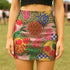 A woman wearing a colorful, patterned mini skirt with various fruits and floral designs.