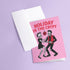 A 5x7 inch greeting card with a vibrant pink background and red retro text reading 'HOLIDAY IN THE CRYPT'. The illustration shows a male and female punk rock skeleton dancing under a red skull disco ball. The female skeleton has a mohawk and wears a black dress. The male skeleton has a mohawk and wears a black jacket with a red vest. Inside, the message reads, 'From our crypt to yours. Eat, drink, and be scary.' The style is a graphic, punk aesthetic.