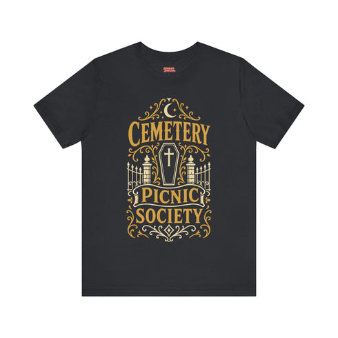A black unisex crewneck graphic t-shirt featuring an ornate Victorian-inspired emblem printed on the chest in vintage gold and off-white. The centralized, symmetrical design showcases a classic coffin with a cross on the lid, flanked by wrought-iron cemetery gates. Beautiful scrollwork and decorative filigree flourishes surround the bold, retro serif text reading CEMETERY PICNIC SOCIETY. A crescent moon and stars sit at the top, completing this gothic memento mori graphic shirt.