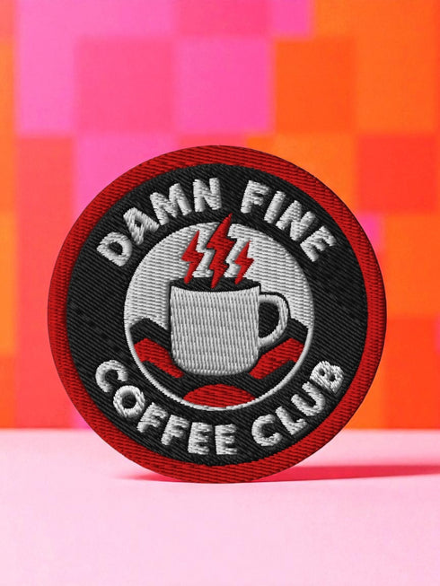 A round, 3-inch embroidered patch with a thick, red merrowed border for a clean, finished edge. The design features a solid black background with the words 'DAMN FINE' in an arc at the top and 'COFFEE CLUB' in an arc at the bottom, all in a bold, white, sans-serif font. In the center, a detailed white coffee mug with a black handle is depicted. Two bright red lightning bolts emerge from the top of the mug, symbolizing energy, reminiscent of the Black Lodge floor from Twin Peaks.