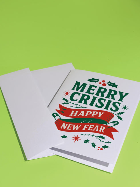 A 5x7 alternative holiday card with a white background and bold, punk-inspired typography. The text reads "Merry Crisis Happy New Fear" in dark green and red. The design features graphic elements like holly, stars, and safety pins, giving it a sarcastic, goth aesthetic. The inside message says "Consider this card your coping mechanism." This snarky, dark humor greeting card is perfect for a funny, unconventional Christmas, capturing a mental health humor and anti-capitalist vibe.