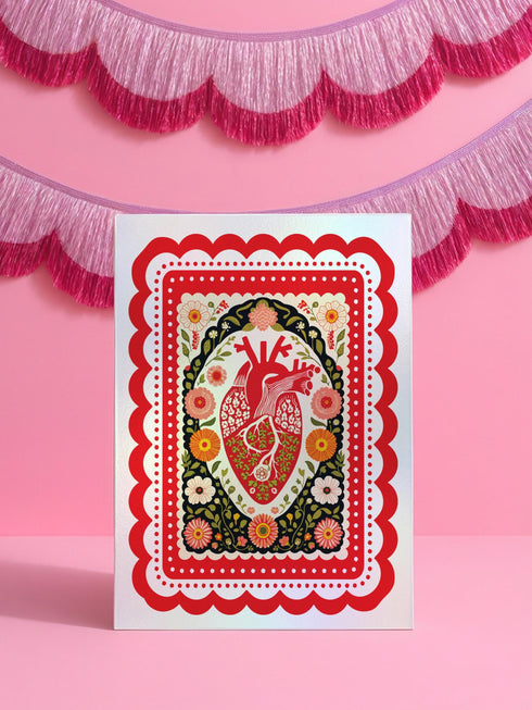 Realistic anatomical heart illustration printed in high contrast ink on a premium 5x7 inch shimmery pearlescent greeting card. The biological heart drawing features detailed arteries, veins, and ventricles, styled with a vintage medical or folk art aesthetic. The cardstock has a visible iridescent sheen. Blank inside valentine card shown with a white peel and seal envelope. Perfect for gothic decor, medical student gifts, cardiology nurse appreciation, and dark academia stationery collections.