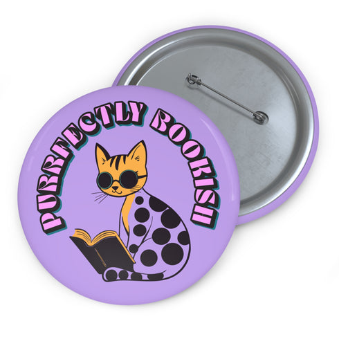 Purple button pin featuring a yellow cat wearing sunglasses and reading a book, with "Purrfectly Bookish" text curved around the edge