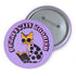 Purple button pin featuring a yellow cat wearing sunglasses and reading a book, with "Purrfectly Bookish" text curved around the edge