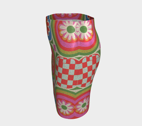 A vibrant bodycon mini skirt featuring a structured grid of retro geometric medallions. The pattern includes concentric circles in red, yellow, and blue, stylized daisy flower motifs, and red and white checkered squares. The skirt has a high-waist elastic band and a smooth, matte performance knit texture. The background is a neutral off-white. This maximalist design utilizes saturated primary colors to create a 70s-inspired psychedelic aesthetic. No purple or navy is present in the print.